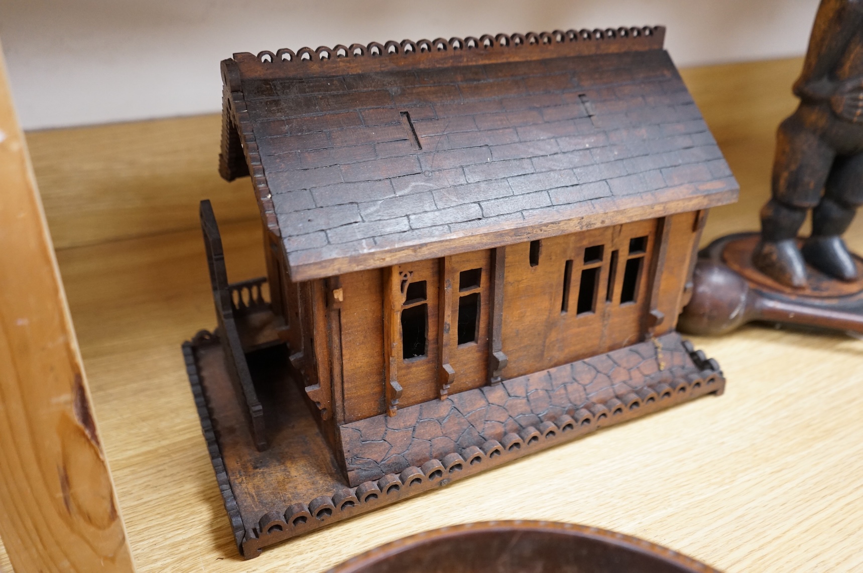 An early 20th century Black Forest carved walnut musical footed dish together with a model of a house (2)